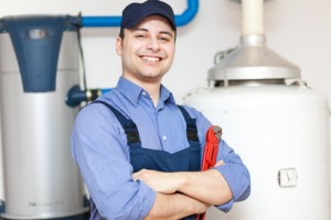 Plumber smiling confidently with a wrench, standing next to water heaters, representing plumbing services and water heater installation options.