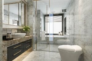 Modern bathroom remodel featuring a sleek shower enclosure, elegant marble tiles, stylish countertop with sink, and a contemporary toilet, emphasizing aesthetic upgrades and plumbing considerations.