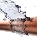Water splashing from a burst copper pipe, demonstrating plumbing emergencies for Green Hills Plumbing services.