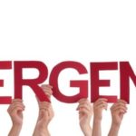 Hands holding large red "EMERGENCY" letters, highlighting urgent plumbing issues by Green Hills Plumbing.