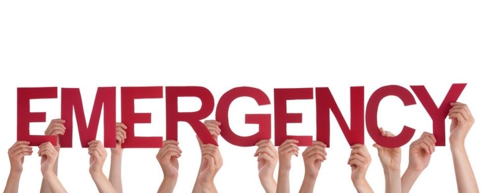 Hands raised holding bold red letters spelling "EMERGENCY," emphasizing urgent plumbing services by Green Hills Plumbing.