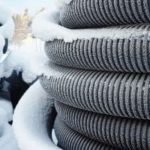 Frost-covered coiled hoses illustrating frozen pipe prevention by Green Hills Plumbing in winter conditions.
