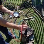 Person checking pressure gauge for plumbing maintenance by Green Hills Plumbing, Nashville, TN.