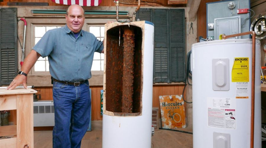 Man inspecting old and new water heaters, highlighting plumbing maintenance at Green Hills Plumbing in Nashville, TN.
