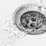 Close-up of a sink drain featuring water flow and bubbles, showcasing Green Hills Plumbing's drain cleaning expertise.