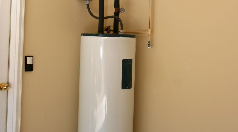 Large white cylindrical water heater with piping and control panel, provided by Green Hills Plumbing for home plumbing needs.