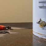 Water heater with visible corrosion and tools nearby, illustrating signs of wear and the need for maintenance or replacement, relevant to plumbing services in Nashville, TN.